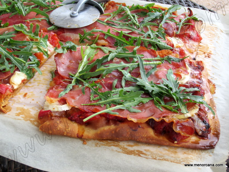Pizza con tomate asado, jamón y rúcula